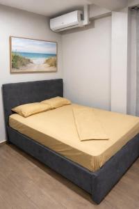a bed in a room with a painting on the wall at Southgate Residence in Paramaribo