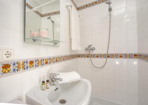 a white bathroom with a sink and a mirror at Antonios Hostal in Sitges