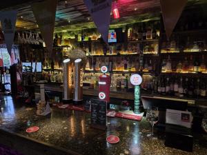 a bar with a counter with a lot of alcohol at Postmasters House in Helston