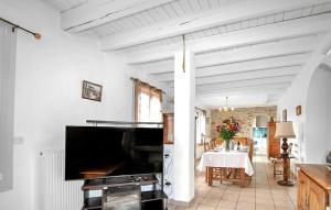 a living room with a large television and a table at Authentique Maison Piscine in Saint-Amans-Valtoret