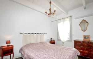 a bedroom with a bed and a window and a chandelier at Authentique Maison Piscine in Saint-Amans-Valtoret