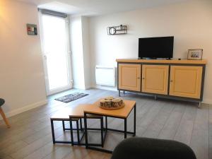 a living room with a tv and a table at Le Gîte Du Vigneron in Saulcet