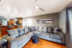 a living room with a large couch and a kitchen at The Adventure Pad, Unit 1 in Branson