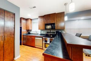a kitchen with wooden cabinets and a black counter top at The Adventure Pad, Unit 1 in Branson