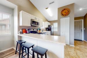 a kitchen with a counter with three stools and a clock at Lake Adventures at Eagle's Nest in Branson