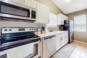 a kitchen with stainless steel appliances and white cabinets at Lake Adventures at Eagle's Nest in Branson