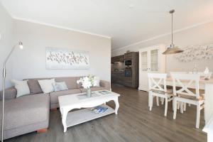 a living room with a couch and a table at Haus Vogelflug strandleev3 in Fehmarnsund