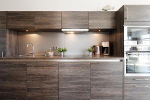 a kitchen with wooden cabinets and a sink at Haus Vogelflug strandleev3 in Fehmarnsund
