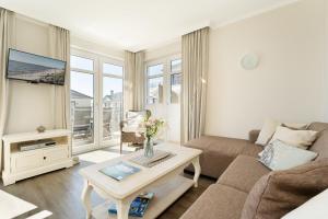 a living room with a couch and a table at Haus Vogelflug strandleev3 in Fehmarnsund +26 photos