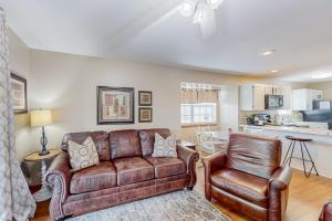 a living room with a leather couch and a chair at Treetop Tranquility in Branson
