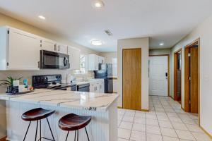 a kitchen with a counter and two bar stools at Treetop Tranquility in Branson