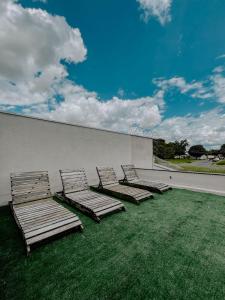 a group of chaise lounges and chairs on a wall at Suítes em casa ampla com área gourmet in Uberlândia