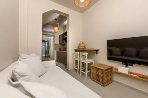 a living room with a white couch and a flat screen tv at The Old Port in Limenas +7 photos