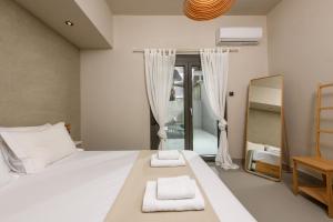 a bedroom with a white bed and a mirror at The Old Port in Limenas