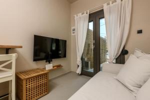 a room with a tv and a bed and a window at The Old Port in Limenas