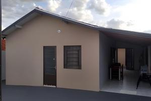 a white house with a porch with a window at Casa do Bruno, 600 mt do thermas in Olímpia