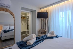 a bedroom with a bed with towels on it at Azor Signature Flats - III in Ponta Delgada