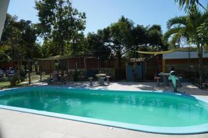 a swimming pool in a yard with a person in the water at Pousada Recanto dos Pássaros in Linhares