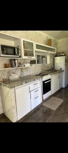 a kitchen with white cabinets and a counter top at Hostel francis in Tristán Suárez