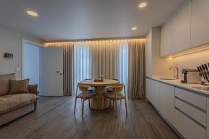 a kitchen and living room with a table and a couch at Azor Signature Flats - IV in Ponta Delgada