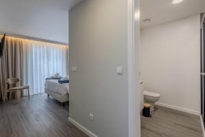 a bedroom with a bed and a toilet in a room at Azor Signature Flats - IV in Ponta Delgada +31 photos