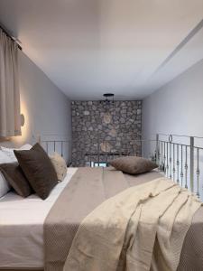 a bedroom with a large bed and a stone wall at A Casa Di Zoi in Archangelos