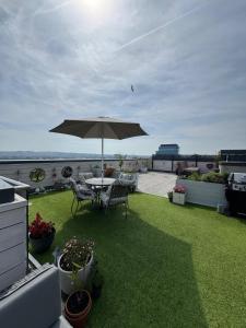 a patio with an umbrella and a table and chairs at James Clow Boutique Bed & Breakfast in Belfast