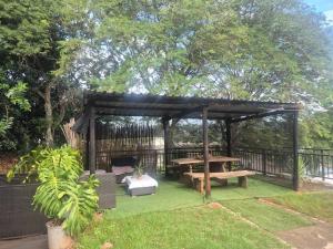 a wooden pavilion with a picnic table and a bench at BluSash in Durban