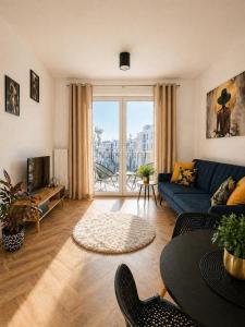 a living room with a blue couch and a large window at Ami Luxury Residence VI CENTRUM - parking- in Iława