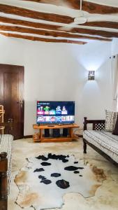 a living room with a tv and a cow rug at Fasha House Malindi in Malindi