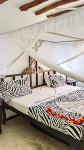 two beds in a room with zebra pillows at Fasha House Malindi in Malindi +37 photos