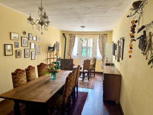 a dining room with a wooden table and chairs at Maison Luard in Bedous