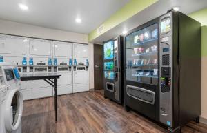 a laundry room with two machines and a table at Extended Stay America Select Suites - Orlando - Airport in Orlando