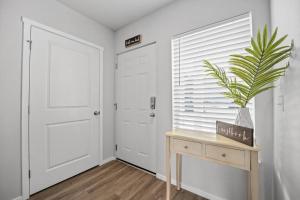 a hallway with a door and a table with a plant at Steps to Dome Breathtaking views parking AC! in Tacoma