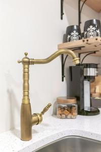 a kitchen sink with a gold faucet at 6th Ave district studio Quiet Prkng in Tacoma