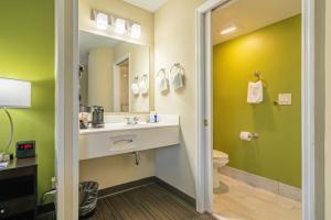 a bathroom with a sink and a toilet and a mirror at Sleep Inn Murfreesboro Shopping District in Murfreesboro +23 photos