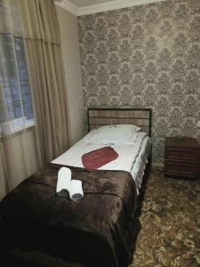 a bedroom with a bed with two white towels on it at Dachi Apartment in Sighnaghi
