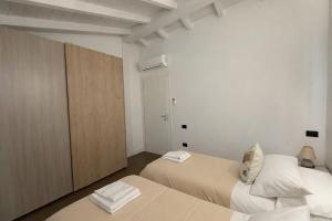 a bedroom with two beds and a closet at Apt. Virgo - Oasi di Menaggio in Menaggio +34 photos