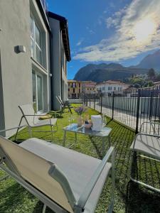 a patio with a table and chairs on a balcony at Apt. Virgo - Oasi di Menaggio in Menaggio