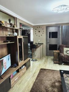 a living room with a couch and a television at Dachi Apartment in Sighnaghi