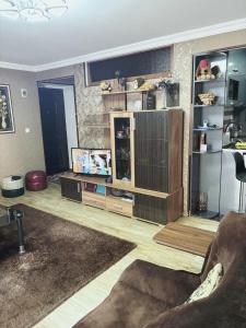 a living room with a entertainment center and a television at Dachi Apartment in Sighnaghi