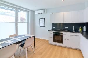 a kitchen with white cabinets and a table and chairs at Burgblick Apartment Weinlaub in Bernkastel-Kues