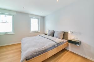 a bedroom with a bed and two windows at Burgblick Apartment Weinlaub in Bernkastel-Kues