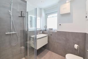 a bathroom with a shower and a sink and a toilet at Burgblick Apartment Weinlaub in Bernkastel-Kues +18 photos