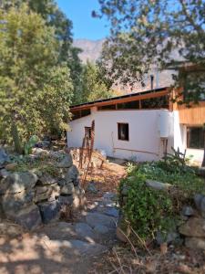 a white house with a stone wall in front of it at Palmera el Refugio in Olmué +10 photos