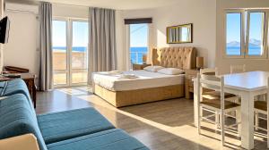 a bedroom with a bed and a table and a couch at Open Sea Apartments in Utjeha