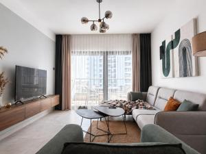 a living room with a couch and a tv at Caesar Blue Collection Nothern Cyprus Family Bedroom Suites in Ayios Dhometios