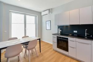 a kitchen with white cabinets and a table and chairs at Burgblick Apartment Schieferblau in Bernkastel-Kues