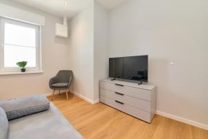 a living room with a television on a dresser at Burgblick Apartment Schieferblau in Bernkastel-Kues