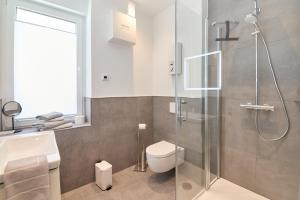 a bathroom with a shower and a toilet and a sink at Burgblick Apartment Schieferblau in Bernkastel-Kues +26 photos